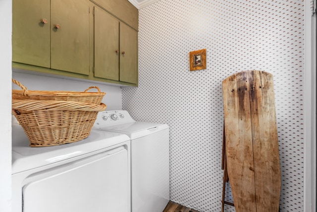 clothes washing area featuring cabinets and washer and dryer