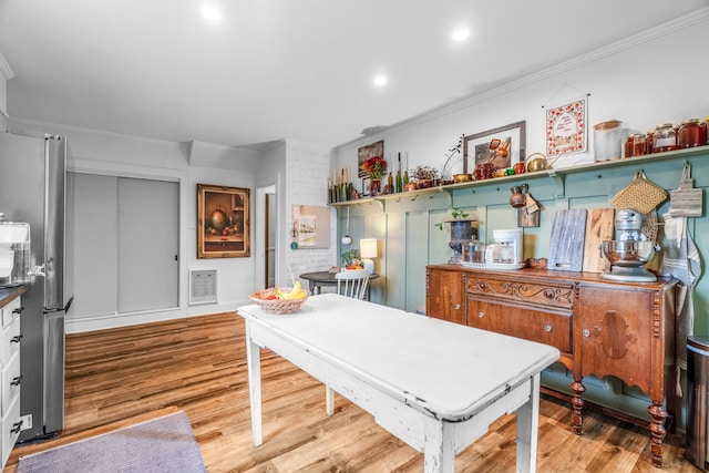 interior space featuring crown molding and light hardwood / wood-style flooring