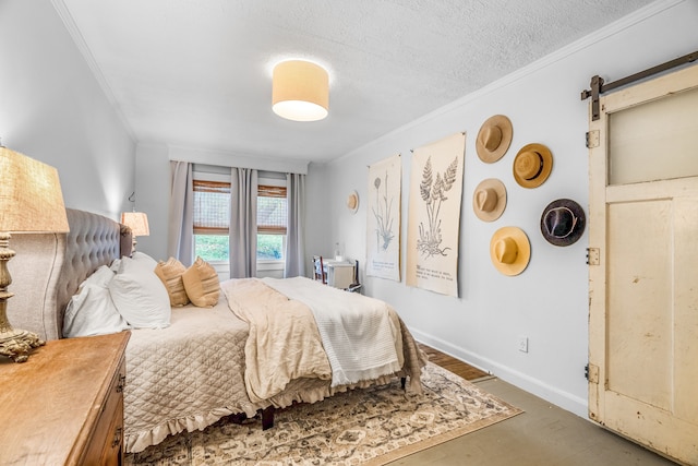 bedroom with a textured ceiling, a barn door, and crown molding