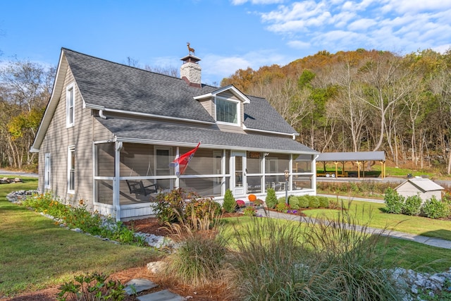 view of front of property featuring a sunroom and a front lawn