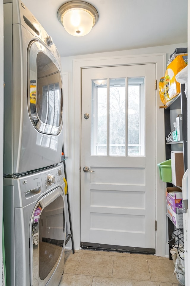 laundry room with light tile patterned floors and stacked washer and dryer