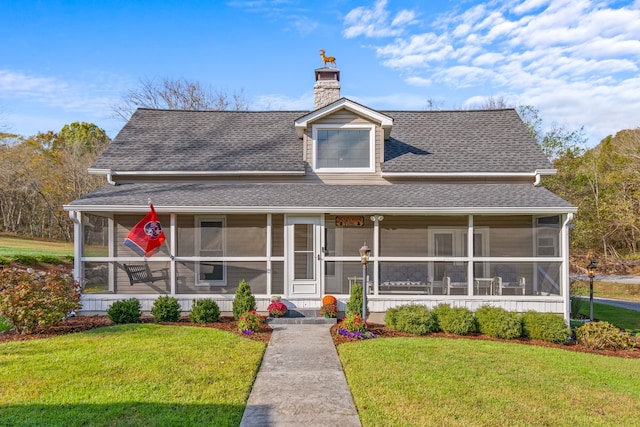 view of front of home featuring a sunroom and a front lawn