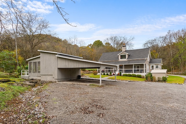 rear view of property with a carport and a sunroom