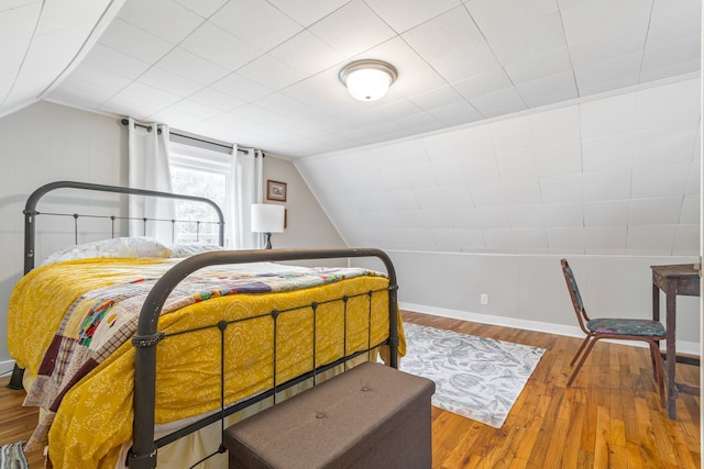 bedroom with wood-type flooring and lofted ceiling