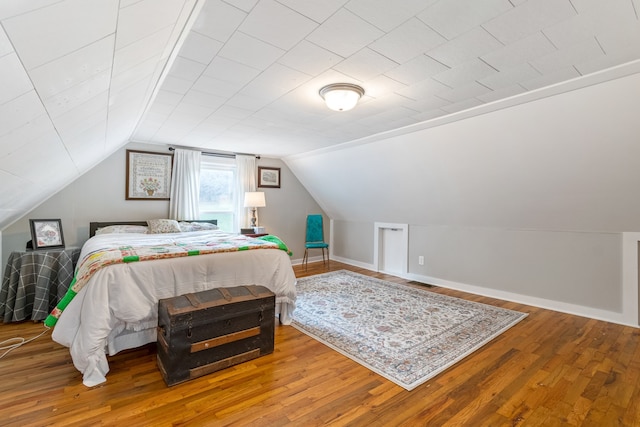 bedroom with lofted ceiling and hardwood / wood-style flooring