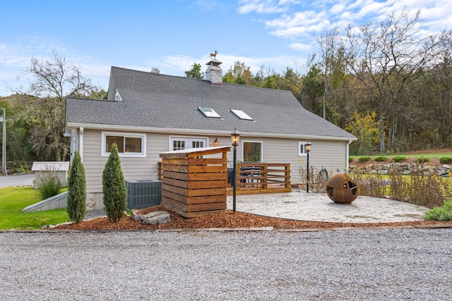 view of front facade with a wooden deck and central AC