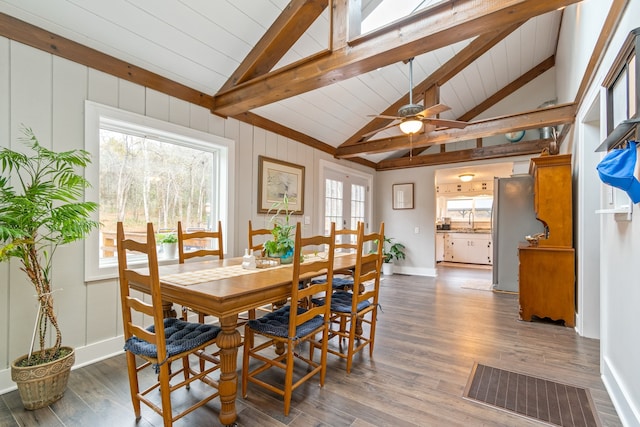 dining area featuring lofted ceiling with beams, dark hardwood / wood-style flooring, and a healthy amount of sunlight