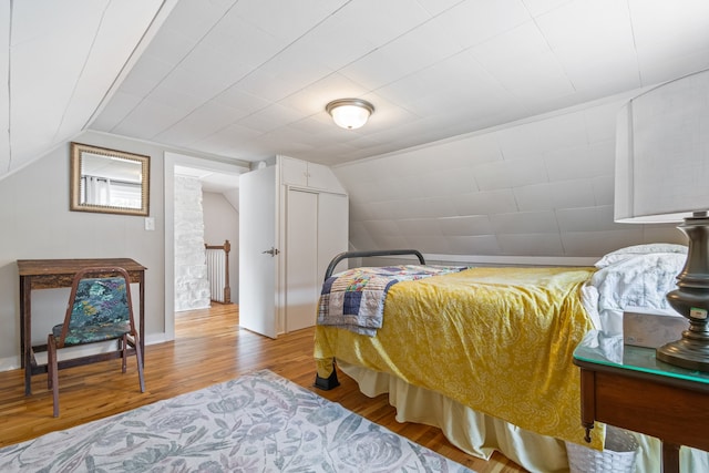 bedroom with light hardwood / wood-style floors and vaulted ceiling