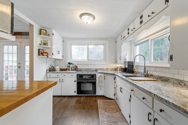 kitchen with decorative backsplash, white cabinetry, plenty of natural light, and black appliances