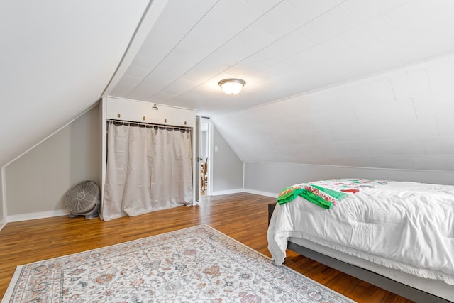 bedroom featuring hardwood / wood-style floors and vaulted ceiling