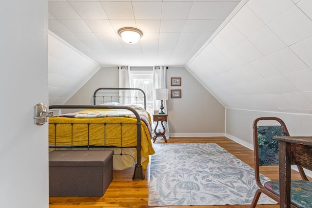 bedroom featuring wood-type flooring and vaulted ceiling