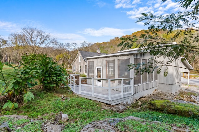 rear view of house with a sunroom and a deck