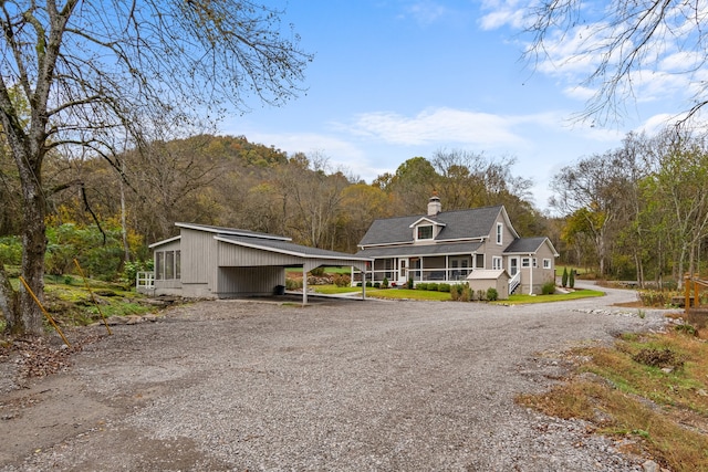 view of front facade featuring covered porch and a carport