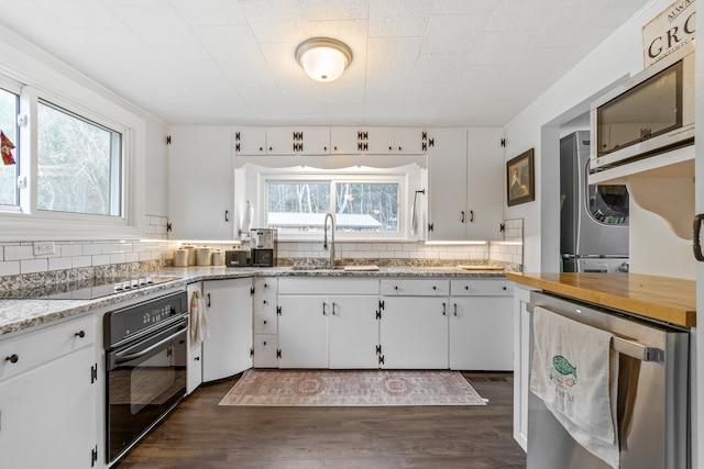 kitchen with black appliances, a healthy amount of sunlight, and white cabinetry