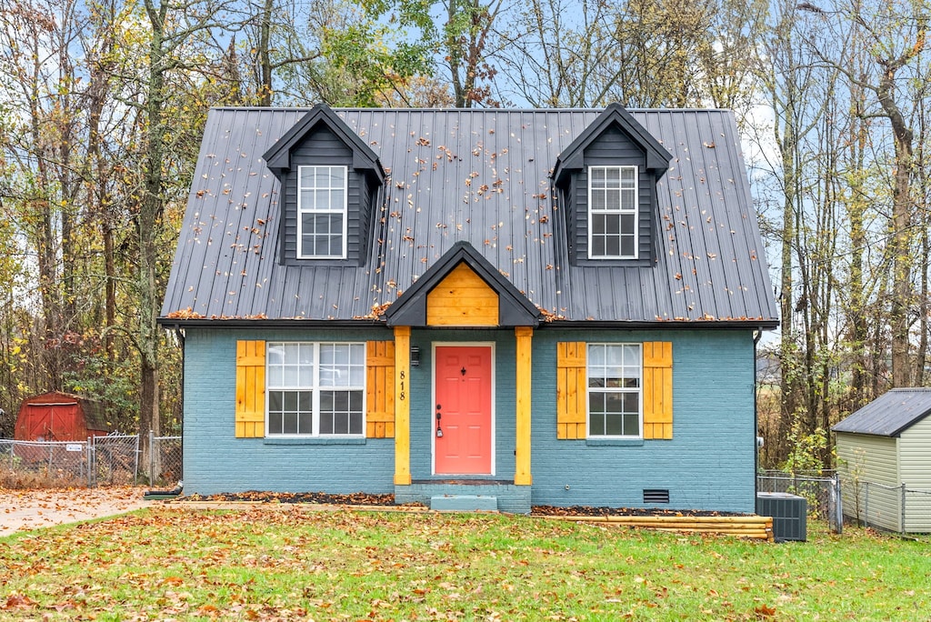 view of front of house featuring a front yard and central AC