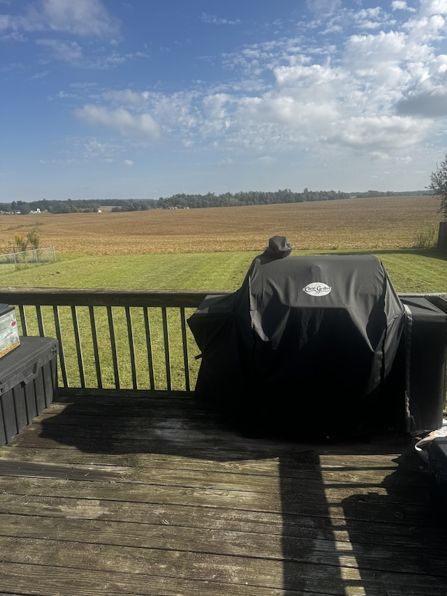 wooden terrace with a rural view and a lawn