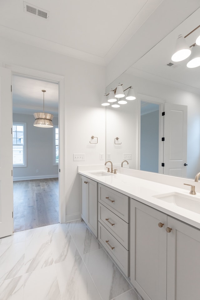 bathroom with crown molding, vanity, and wood-type flooring