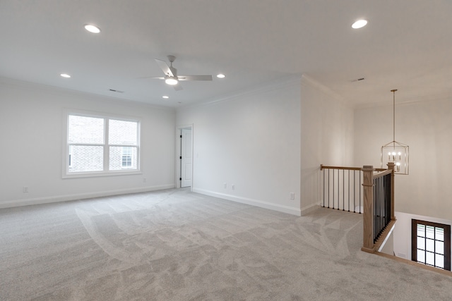 empty room featuring light carpet, ceiling fan with notable chandelier, and crown molding