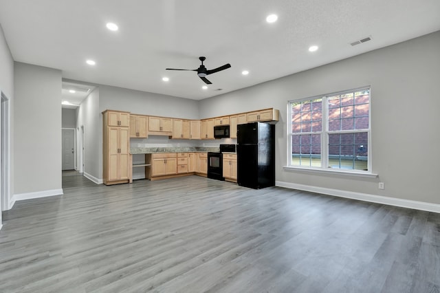 kitchen featuring hardwood / wood-style floors, light brown cabinetry, ceiling fan, and black appliances