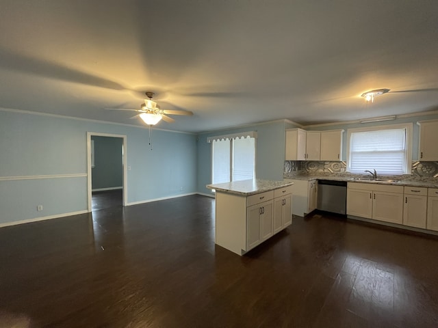 kitchen with tasteful backsplash, stainless steel dishwasher, dark wood-type flooring, sink, and white cabinetry