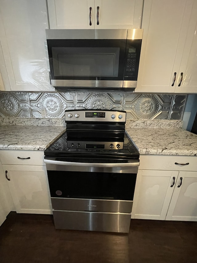 kitchen featuring white cabinets, light stone countertops, and appliances with stainless steel finishes