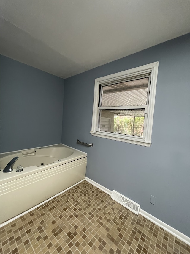 bathroom with a tub and tile patterned flooring