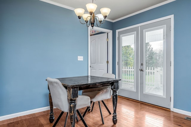 dining room with crown molding, french doors, a chandelier, and hardwood / wood-style flooring