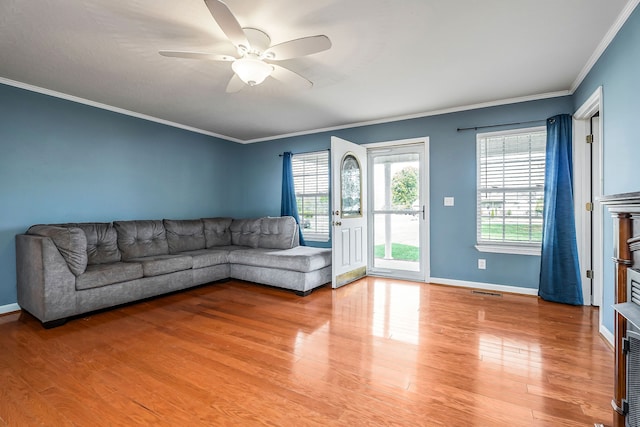 living room with hardwood / wood-style flooring, ceiling fan, and ornamental molding