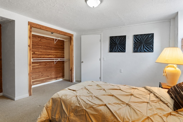 carpeted bedroom featuring a textured ceiling, a closet, and wood walls