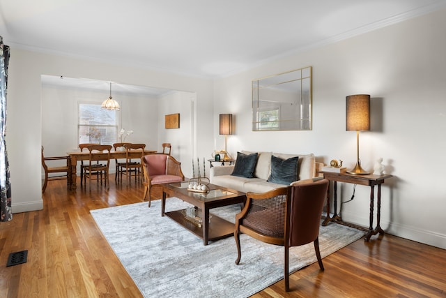 living room featuring hardwood / wood-style flooring and ornamental molding