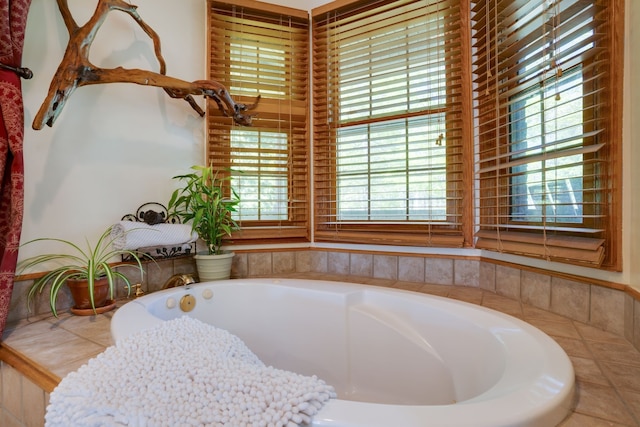 bathroom featuring tiled bath and a healthy amount of sunlight