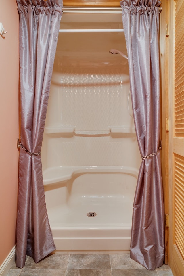 bathroom with a shower with curtain and tile patterned flooring