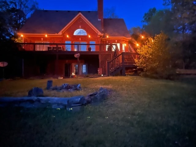 back house at twilight featuring a wooden deck