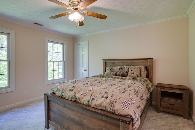 carpeted bedroom with a textured ceiling, ceiling fan, and crown molding