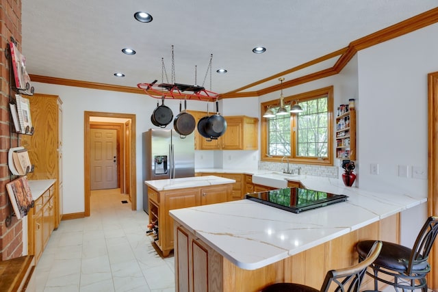 kitchen featuring crown molding, hanging light fixtures, black cooktop, kitchen peninsula, and a breakfast bar area