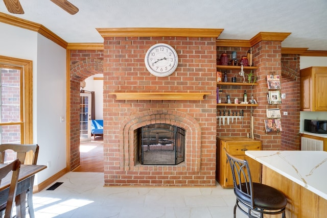 living room featuring a textured ceiling, a fireplace, light hardwood / wood-style floors, and crown molding