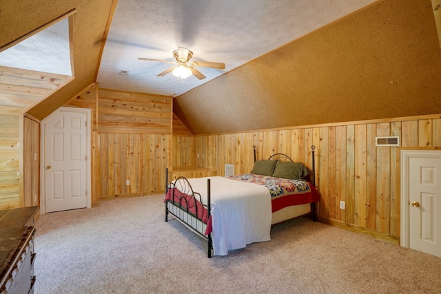 carpeted bedroom with ceiling fan, lofted ceiling, a textured ceiling, and wooden walls