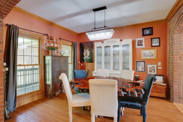 dining area featuring a chandelier, light hardwood / wood-style floors, and ornamental molding