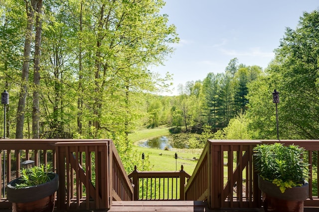 wooden terrace with a lawn and a water view