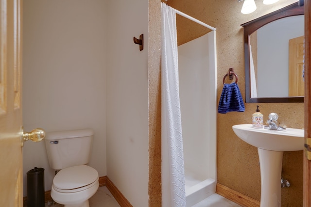 bathroom with a shower with curtain, sink, and toilet