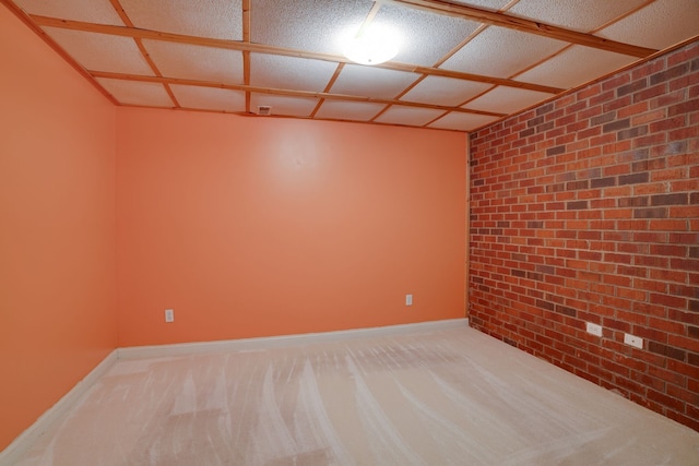 unfurnished room with carpet and brick wall