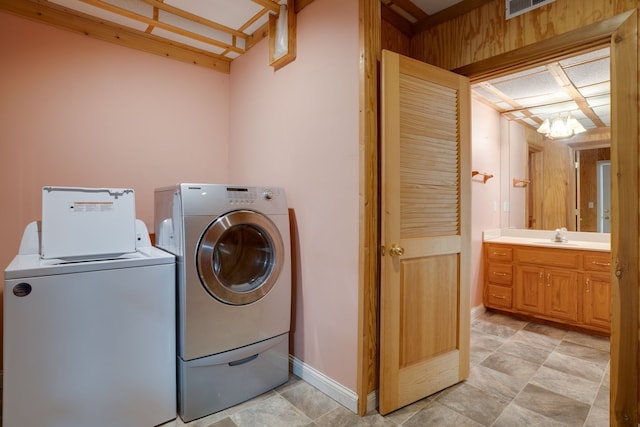 washroom featuring independent washer and dryer, an inviting chandelier, and sink