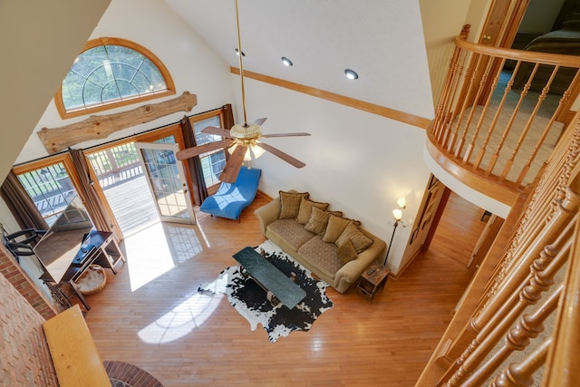 living room featuring light hardwood / wood-style flooring, high vaulted ceiling, and ceiling fan