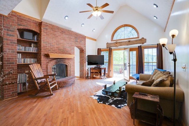 living room featuring hardwood / wood-style floors, ceiling fan, a fireplace, and high vaulted ceiling