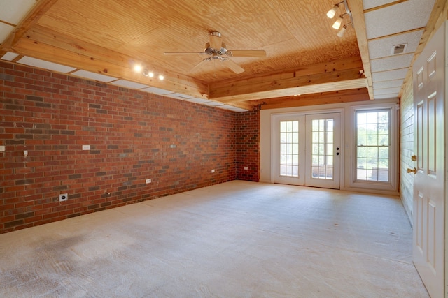 spare room featuring light colored carpet, wood ceiling, ceiling fan, and brick wall