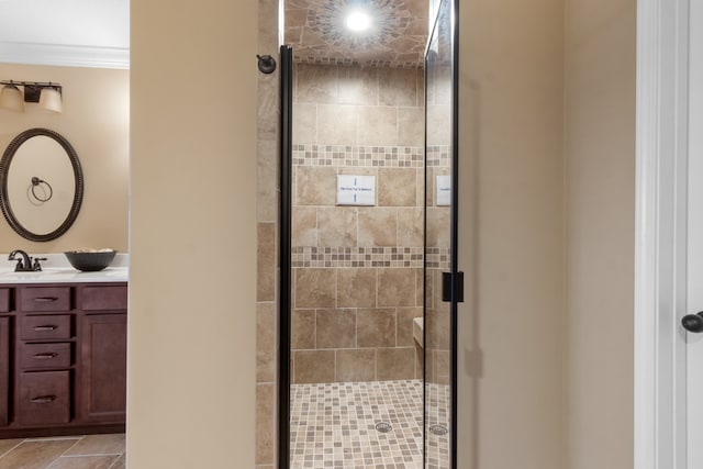 bathroom featuring vanity, tile patterned floors, a shower with door, and ornamental molding