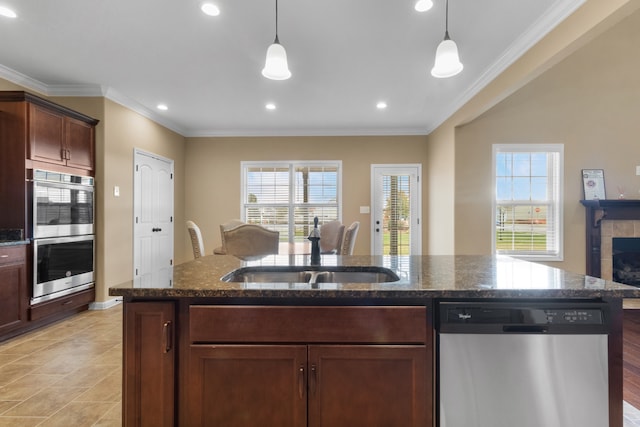 kitchen featuring a tile fireplace, crown molding, dark stone counters, and appliances with stainless steel finishes