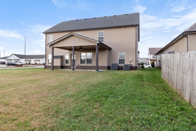 rear view of house with a yard, central AC, and ceiling fan