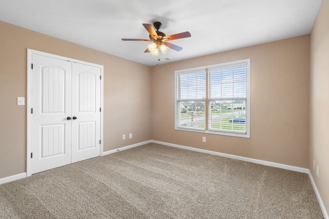 unfurnished bedroom featuring carpet flooring, ceiling fan, and a closet