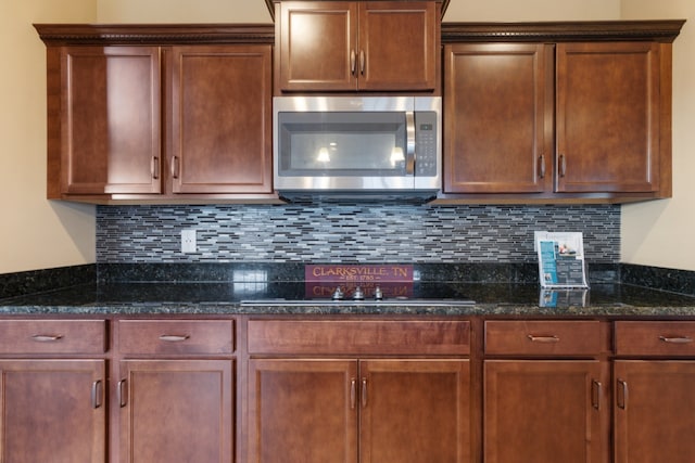 kitchen featuring decorative backsplash and dark stone counters